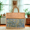 A rectangular juco (jute and cotton blend) tote bag with shorter brown handles and a zippered top. The lower portion of the bag features a printed image resembling Vincent van Gogh's "Almond Blossoms" on a light blue background