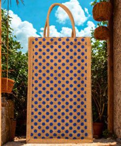 A medium-sized rectangular jute bag with a pattern of evenly spaced blue polka dots on a natural jute background.