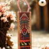 Jute bottle bag with tribal African mask print and red-and-white braided rope handles.