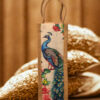 A tall, narrow jute bag with an illustrated peacock and floral design on the front.
