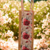 Jute bottle bag with floral print fabric panel and red-and-white rope handles.
