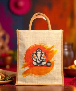 A jute tote bag with an illustration of Lord Ganesha sitting in front of an orange and yellow brushstroke background