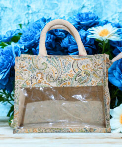 A small canvas tote bag with floral paisley print and a transparent plastic front panel