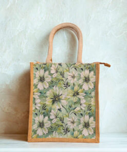 A medium-sized jute bag with white daisy-style floral print on a green background and natural jute handles.