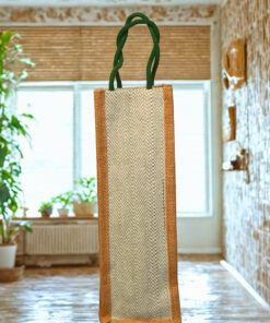 Tall jute bottle bag with herringbone front panel and green braided handles.