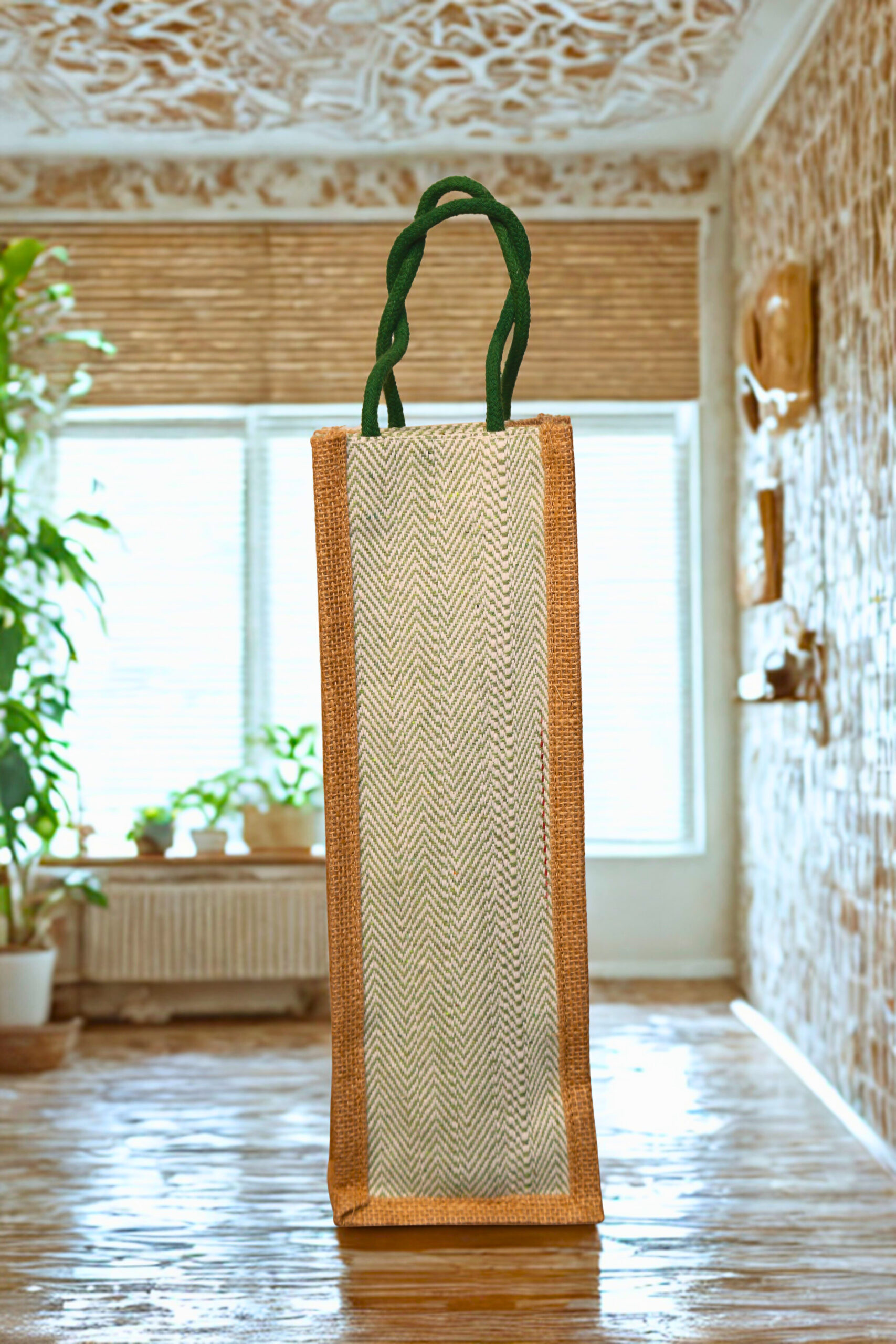 6c5068e3-5696-4ad1-9574-2ee62d03539a Tall jute bottle bag with herringbone front panel and green braided handles.