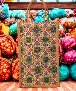 A medium-sized rectangular jute bag with a colorful, repeating geometric and floral-inspired pattern.