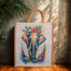 A medium jute bag featuring a colorful watercolor elephant with floral crown and natural jute handles.