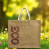 A large natural jute tote bag with white woven handles and the word "ECO" printed vertically in bold brown letters.