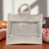 Striped jute bag with transparent front window and round woven handles.