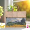 A rectangular juco (jute and cotton blend) tote bag with shorter brown handles and a zippered top. The lower portion of the bag features a printed image resembling Vincent van Gogh's "Wheat Field with Cypresses" with rolling hills