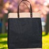 A rectangular tote bag featuring a prominent black textured (likely jute) body