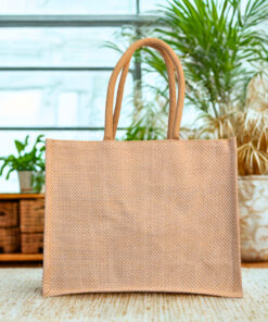 Structured woven jute handbag with rounded rope handles and a boxy rectangular shape in natural beige tone.