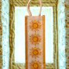 Eco-friendly juco wine bottle bag with rope handle and vibrant sunflower print design on the front.