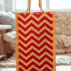 A medium-sized rectangular jute bag with a bold, repeating red and natural jute chevron (zigzag) pattern.