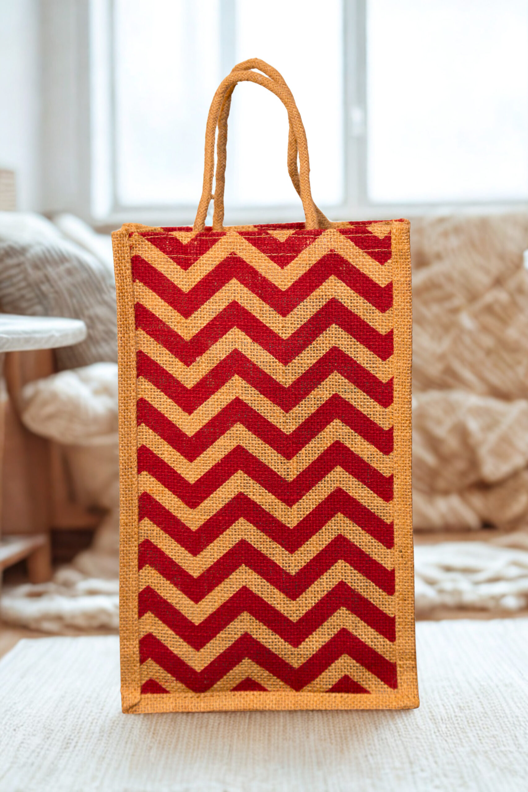 c08fb380-733a-446f-8cee-5cd2124dd0d8 A medium-sized rectangular jute bag with a bold, repeating red and natural jute chevron (zigzag) pattern.