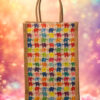 A medium-sized rectangular jute bag featuring a repeating grid pattern of small, colorful elephants.