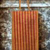 A medium-sized rectangular jute bag with a woven pattern of alternating natural jute and red vertical stripes.