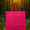 A compact pink jute tote bag with short handles