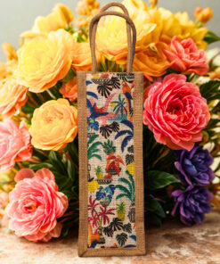 A tall, narrow jute bag with a colorful, whimsical print featuring tropical birds, flowers, and foliage.
