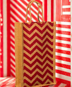 A medium-sized rectangular jute bag with a bold, repeating red and natural jute chevron (zigzag) pattern.