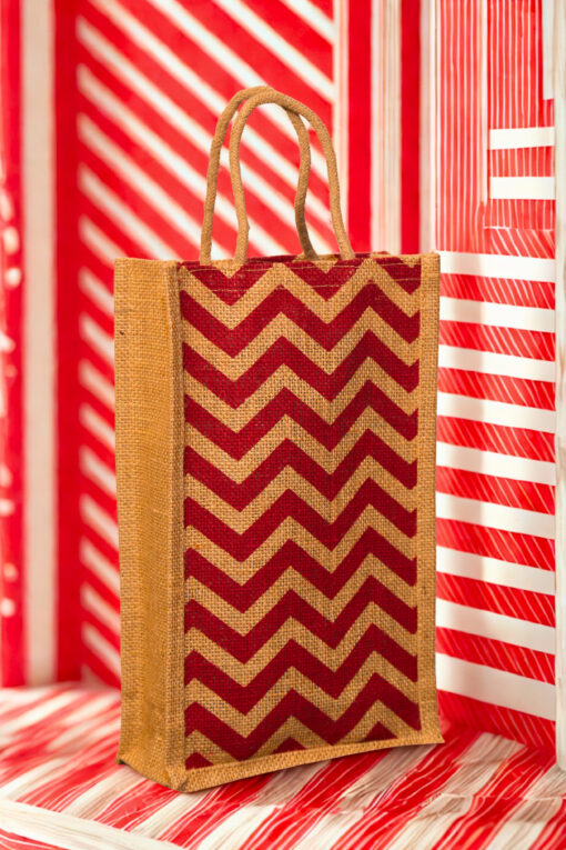 A medium-sized rectangular jute bag with a bold, repeating red and natural jute chevron (zigzag) pattern.